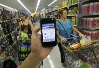 
Un empleado de Wal-Mart muestra la aplicación descontinuada “Scan & Go” para celulares en un establecimiento de San Jose, California. / Foto por: Jeff Chiu / AP